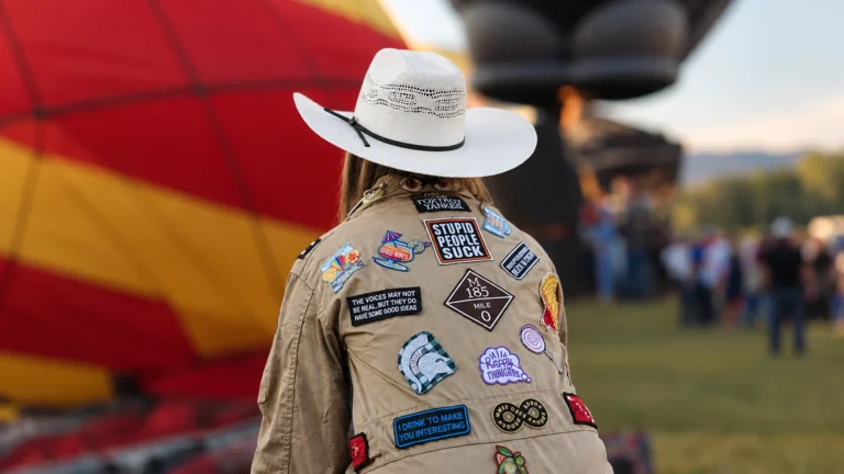 Patches Jackets – Stylish patch-covered jacket with colorful embroidered patches at a hot-air balloon festival.